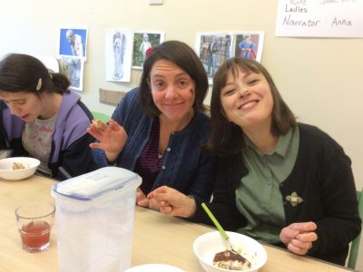 Two women sitting at a table smiling