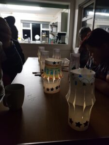 Home made paper lanterns on a table with small lights inside letting off a gentle glow