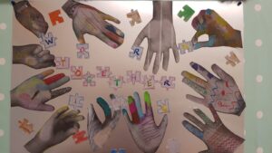 Pictures of hands surrounding jigsaw pieces spelling the words "Working Together"